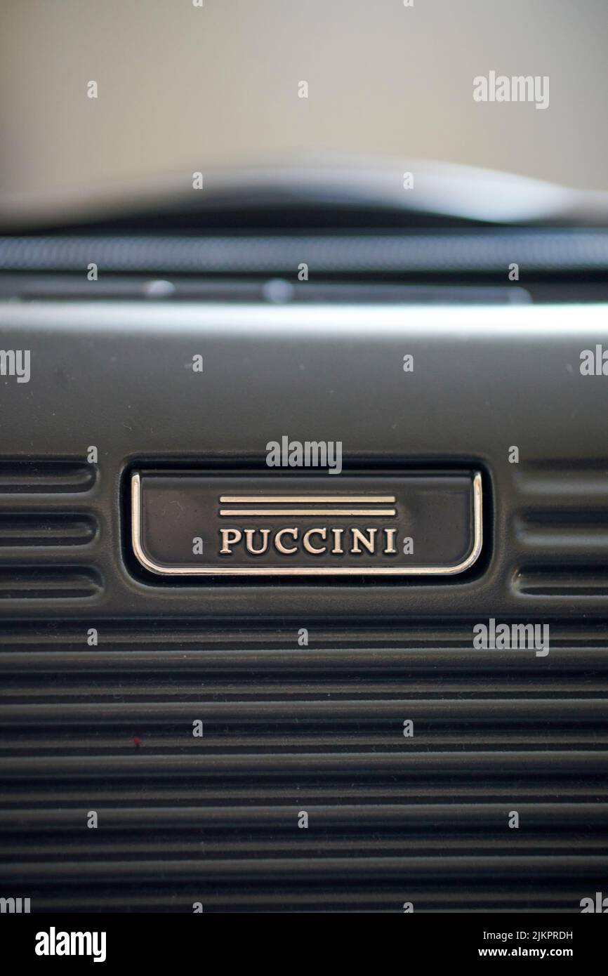 Primo piano verticale di una valigia da viaggio Puccini nera con logo. Foto Stock