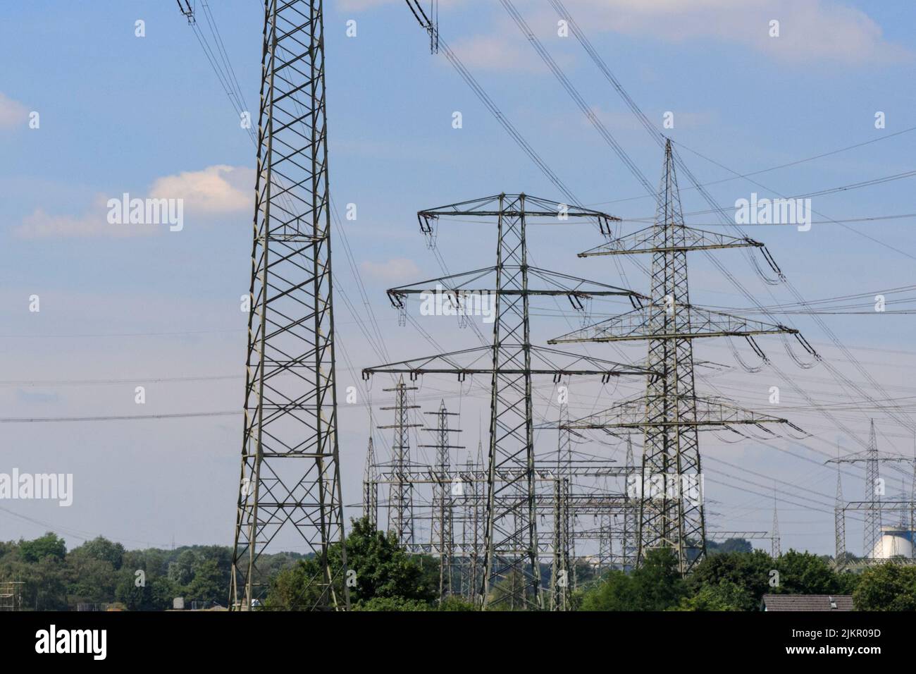 Torri di trasmissione dell'elettricità, piloni o montanti con linee elettriche aeree, vicino alla centrale di generazione dell'energia, Essen, Germania Foto Stock