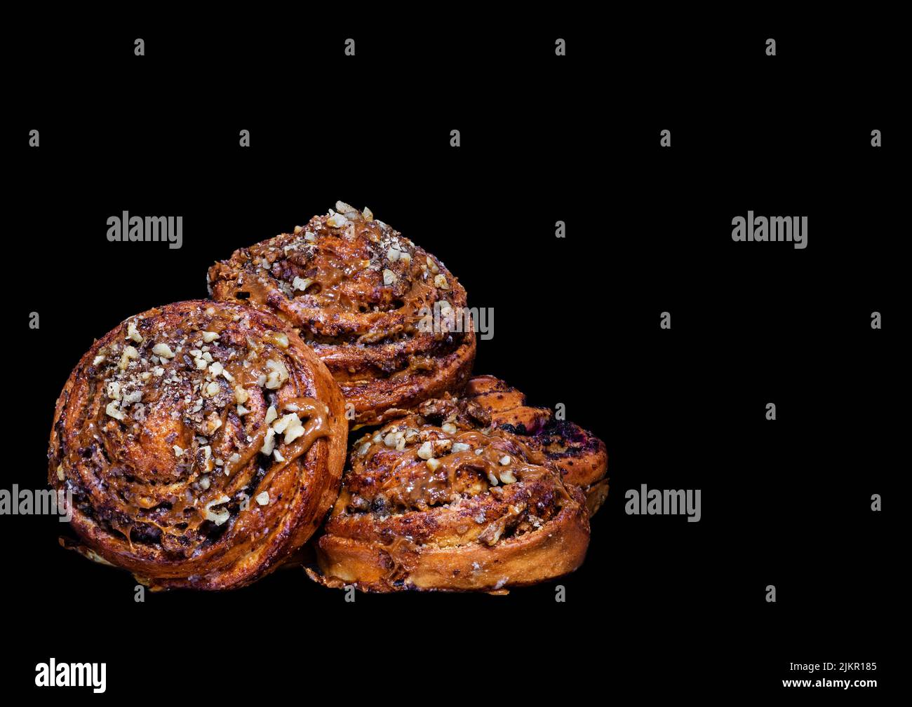 Immagine di panini freschi e deliziosi con crema di noci e semi di papavero su sfondo nero Foto Stock