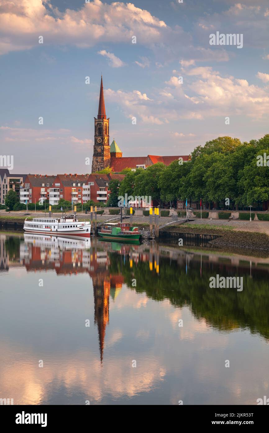 Brema, Germania. Immagine del paesaggio urbano del fiume Brema, in Germania, con il riflesso della Chiesa di Santo Stefano nel fiume Weser all'alba estiva. Foto Stock
