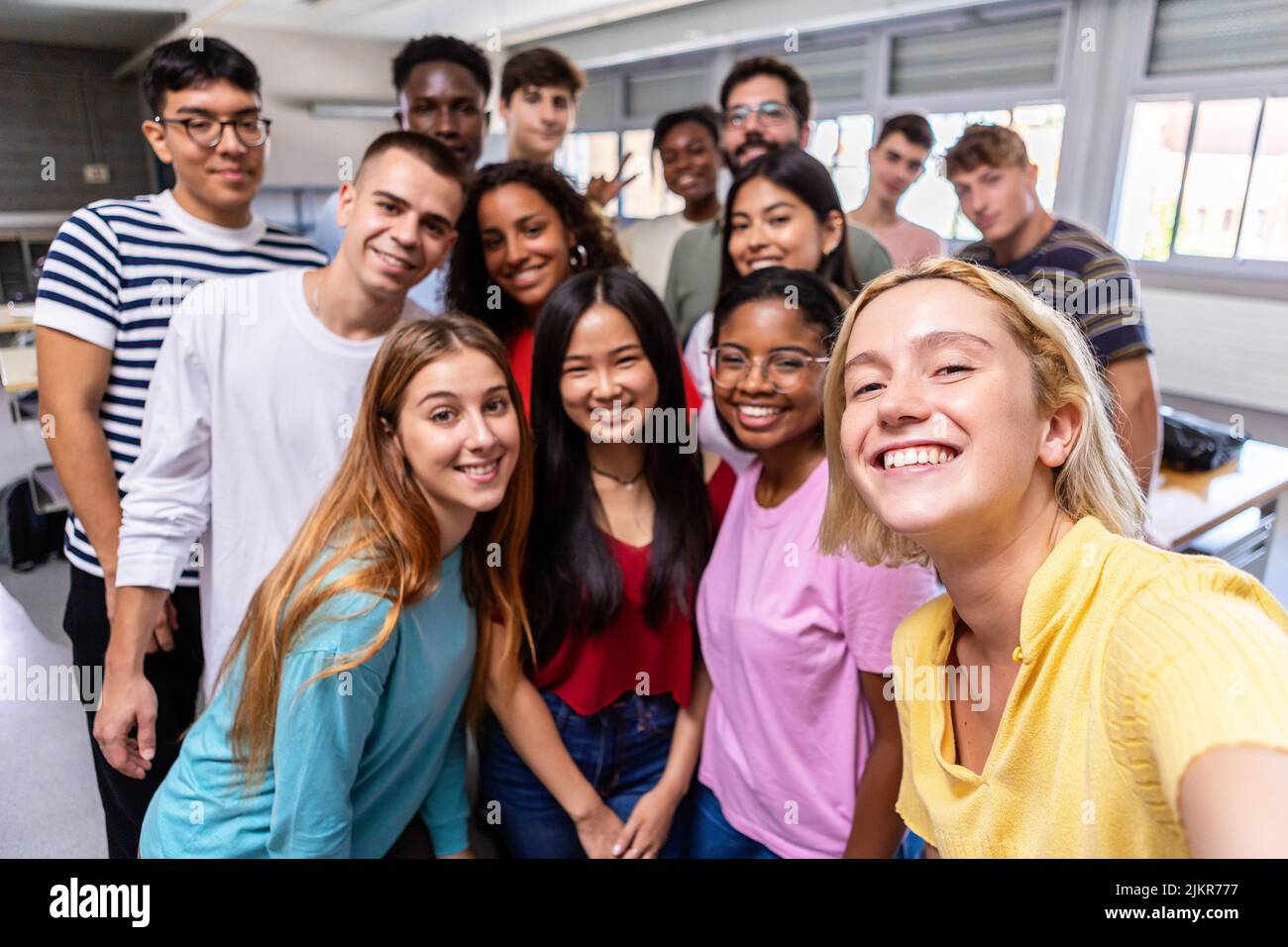Gruppo multirazziale di amici studenti che prendono selfie con insegnante in classe Foto Stock