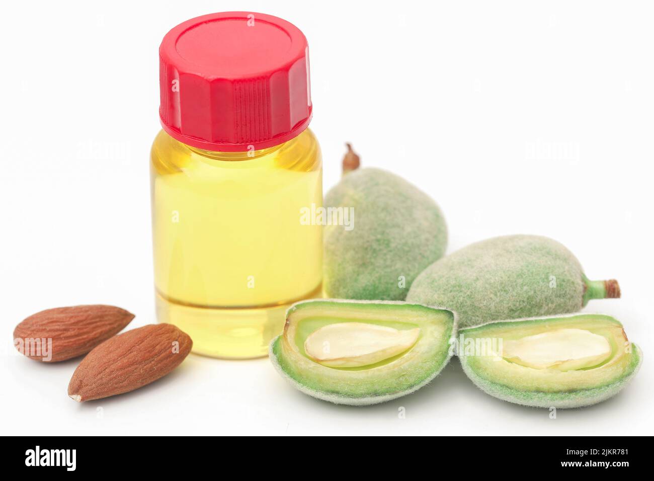 Mandorla verde e pelata e olio essenziale su sfondo bianco Foto Stock