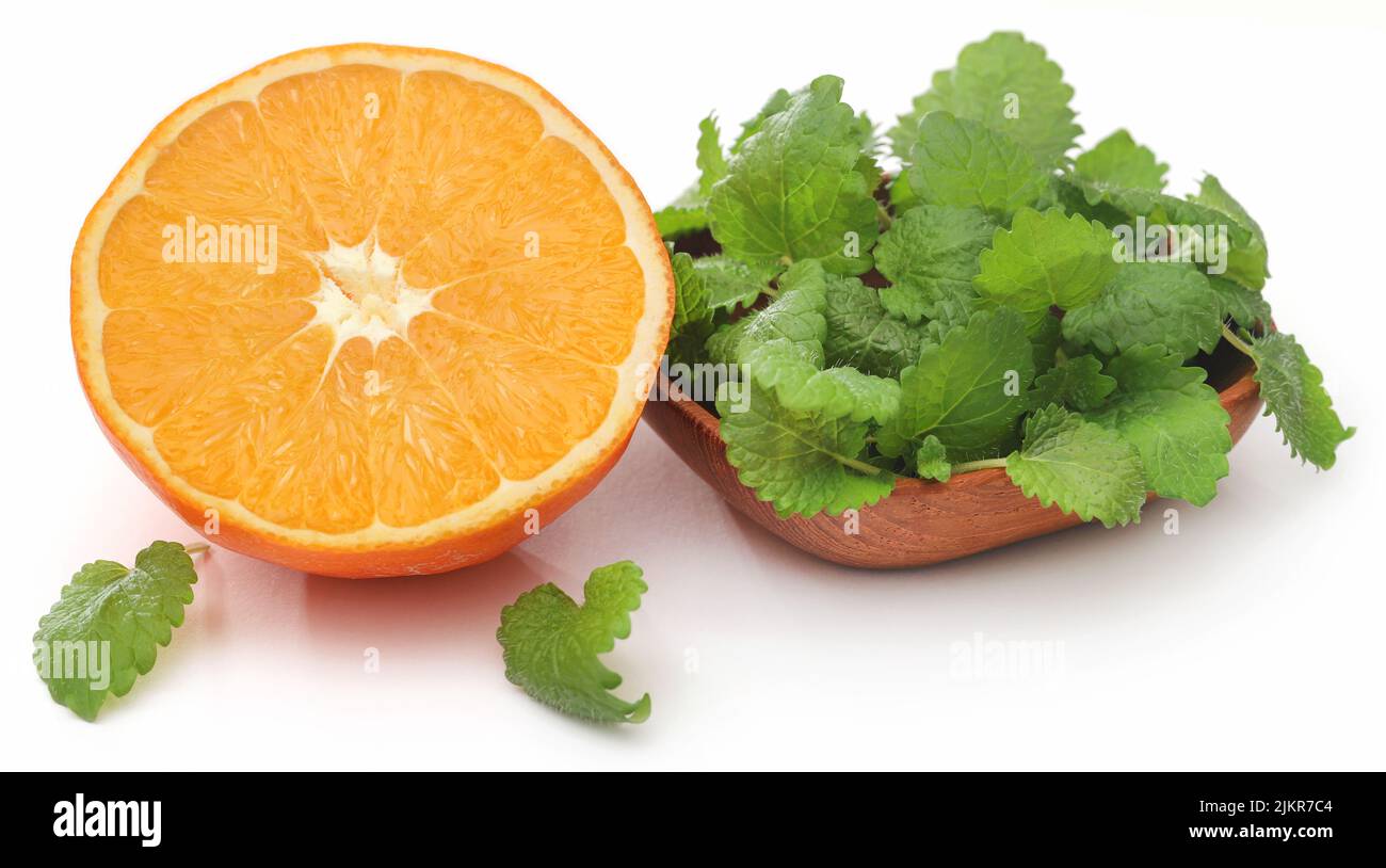 Balsamo al limone con arancia tagliata su sfondo bianco Foto Stock