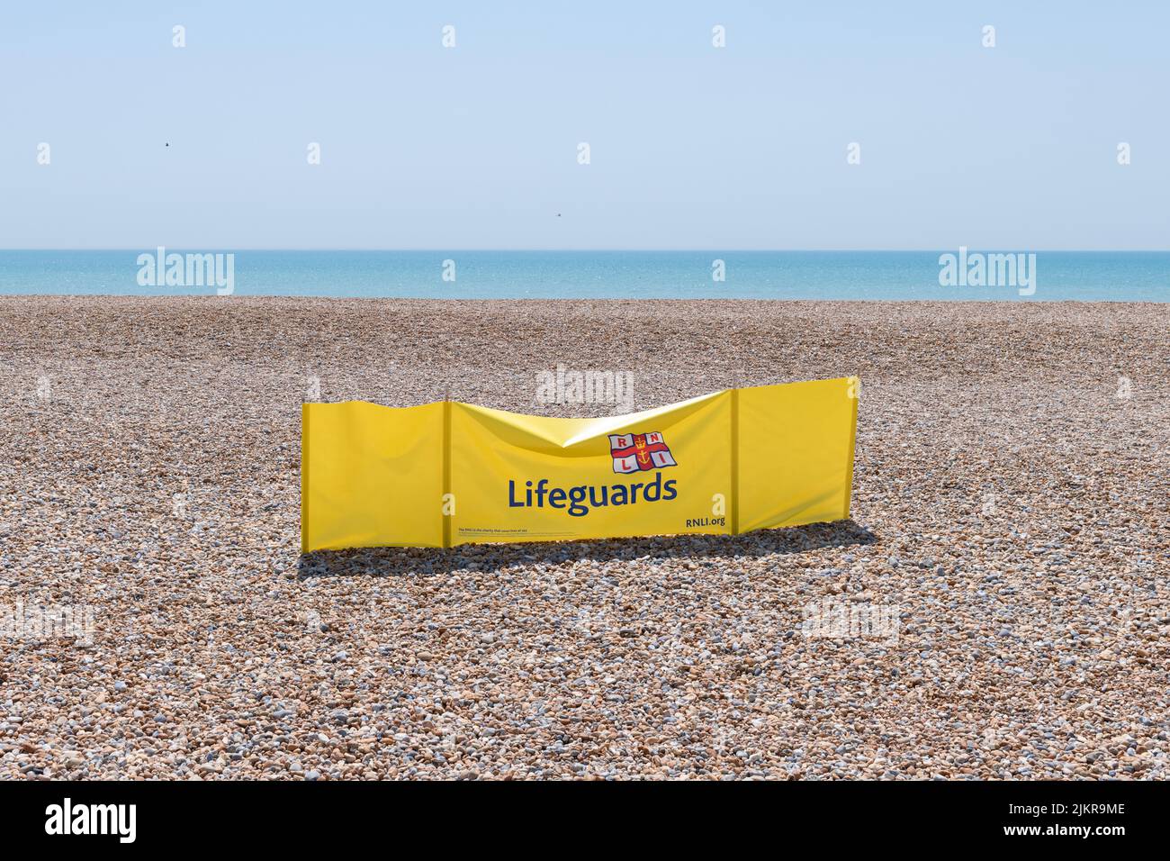 Cartello con la bandiera dei bagnini RNLI sulla spiaggia, Hastings, Inghilterra, Regno Unito Foto Stock