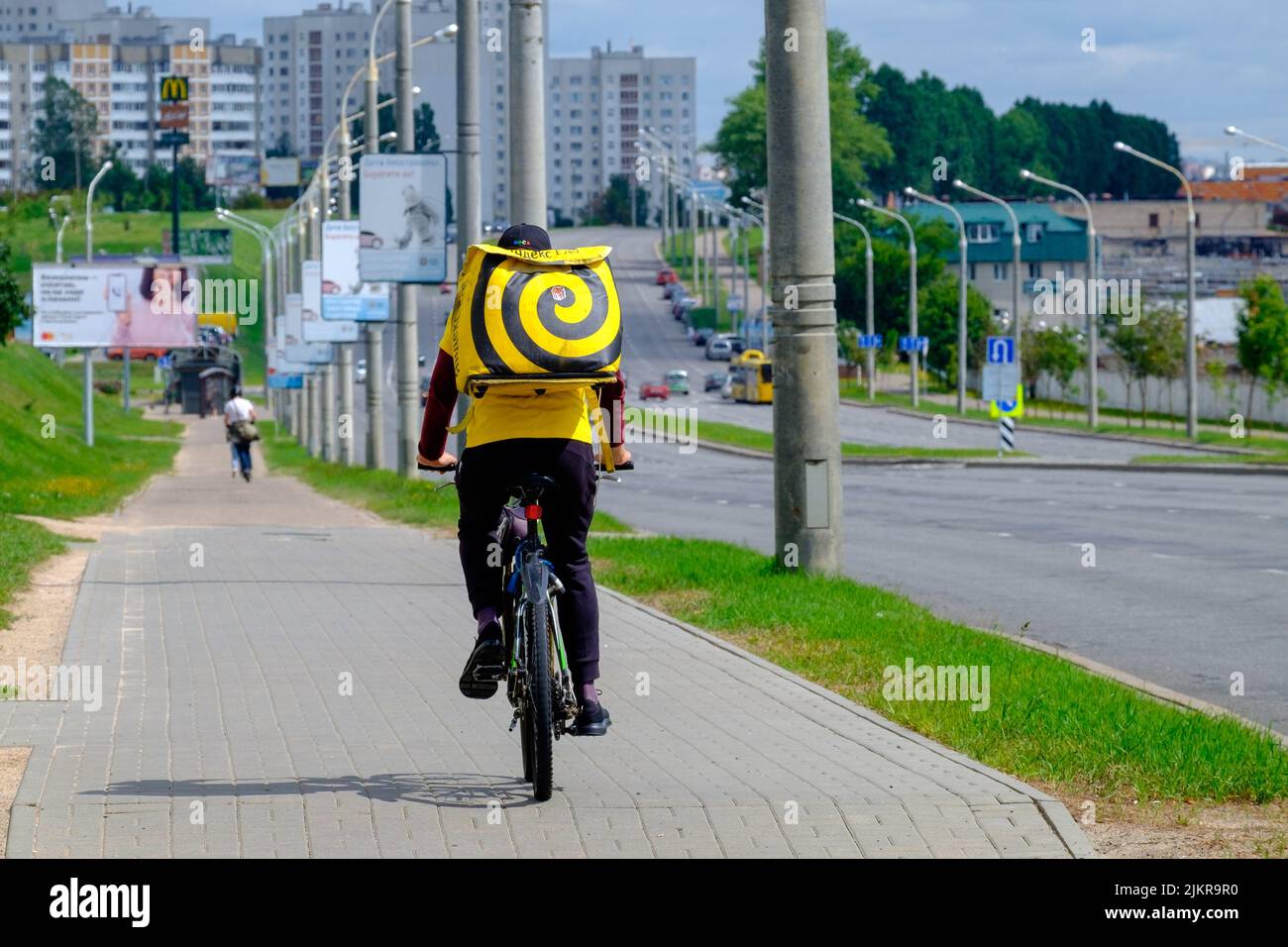 Yandex mangia il corriere consegna cibo consegna un ordine a un cliente in bicicletta Foto Stock