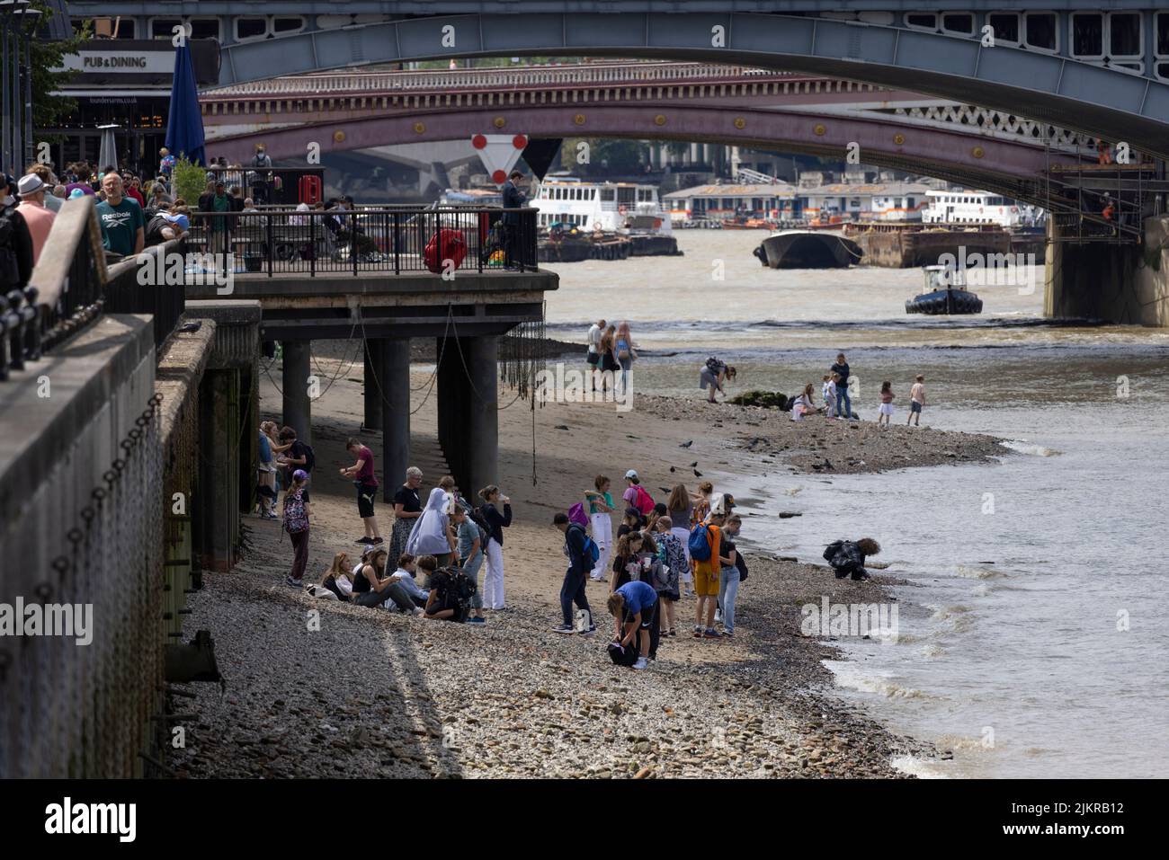 Grandi distese di rocce, ciottoli e spiagge sabbiose di bijou sono esposte sul Tamigi, mentre la gente sta allagando fango con la bassa marea, Londra, Regno Unito Foto Stock