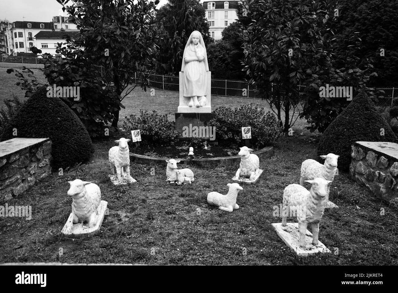 Statua di Bernadette di Lourdes con pecore/agnelli a Lourdes, Francia. Foto Stock