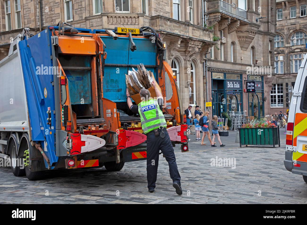 Centro citta', Edimburgo, Scozia, Regno Unito. 3rd ago 2022. Nuvoloso mattinata noiosa nel centro della città per i residenti e i turisti, Royal Mile era occupato con escursioni a piedi e alcuni gruppi che hanno consegnato volantini per gli spettacoli di EdFringe. Nell'immagine: Al di là della chiamata di dovere, un funzionario di voce molto utile assiste un raccoglitore di rifiuti per caricare i rifiuti sul carrello come il traffico stava cominciando a sostenere nel Royal Mile. Credit: ArchWhite/alamy Live news Foto Stock