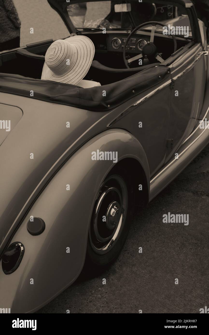 Signora con cappello estivo seduto in auto d'epoca Foto Stock