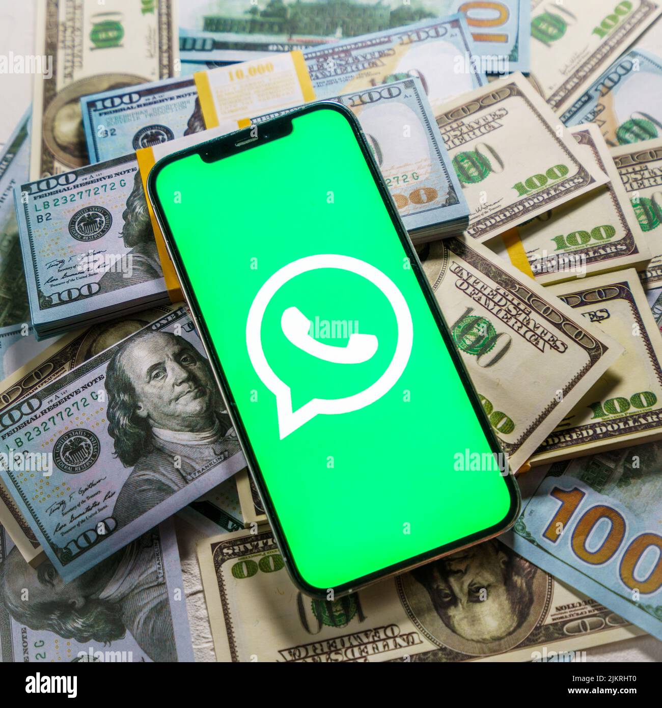 Berlino, Germania - 02 febbraio 2022: Apple iPhone 12 Pro con Messenger WhatsApp sullo schermo e denaro in dollari Foto Stock