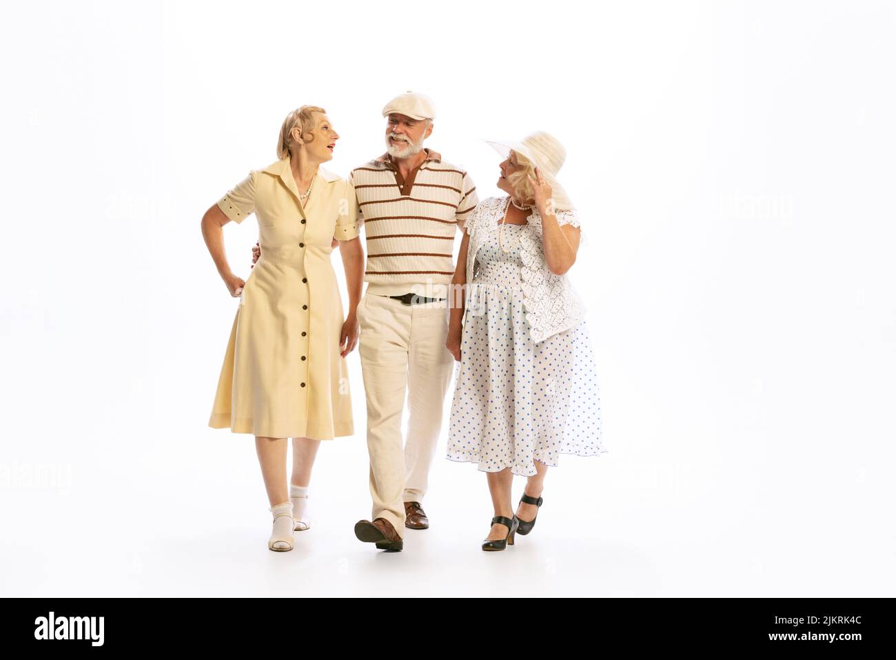 Bell'uomo anziano e due donne affascinanti in abiti vintage stile retrò isolato su sfondo bianco. Concetto di 60s, 70s, stile di moda americano Foto Stock