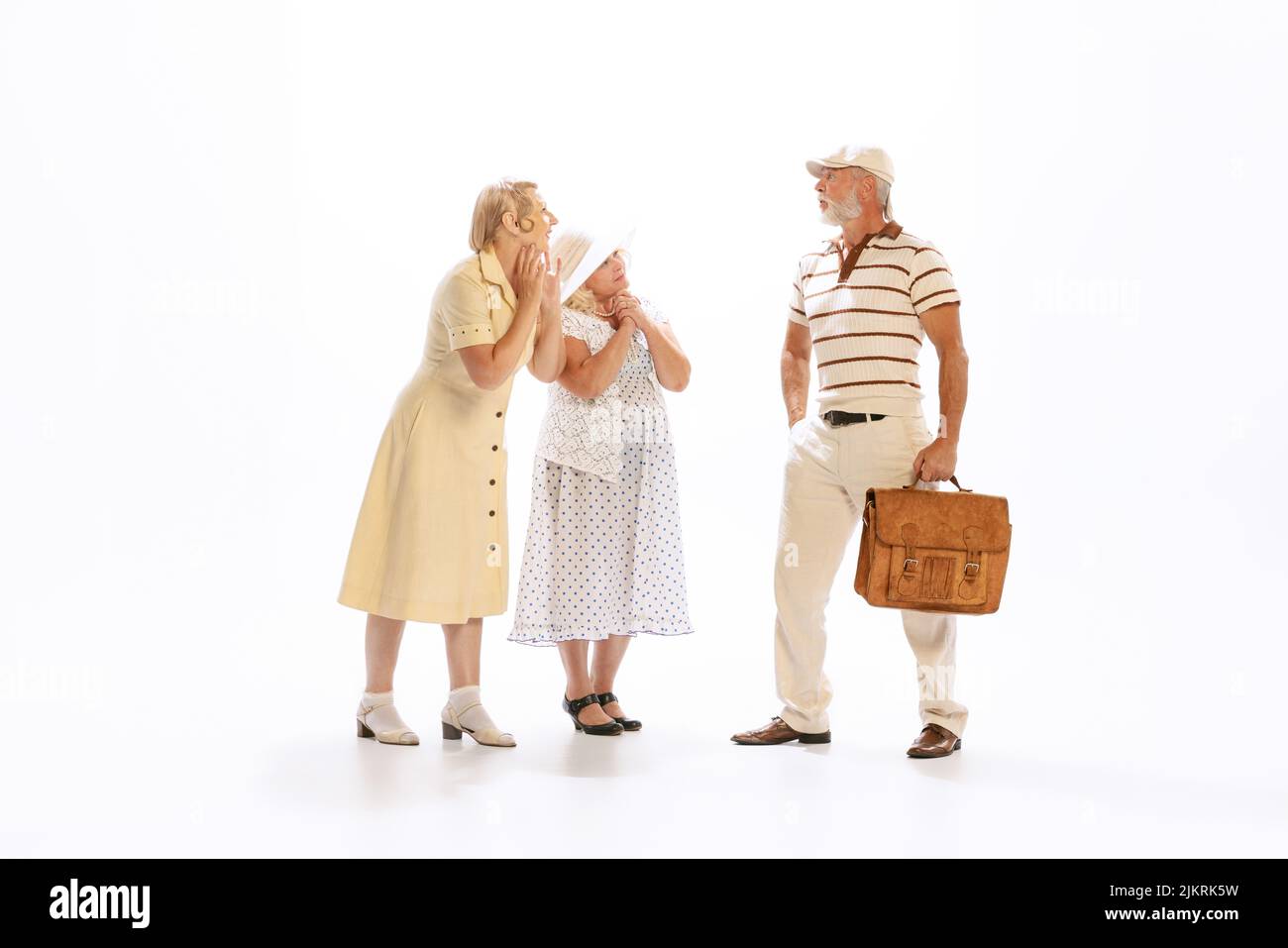 Bell'uomo anziano e due donne affascinanti in abiti vintage stile retrò isolato su sfondo bianco. Concetto di 60s, 70s, stile di moda americano Foto Stock