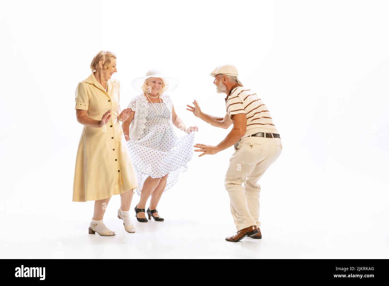 Bell'uomo anziano e due donne affascinanti in abiti vintage stile retrò isolato su sfondo bianco. Concetto di 60s, 70s, stile di moda americano Foto Stock