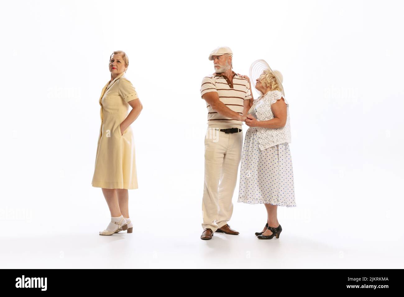 Bell'uomo anziano e due donne affascinanti in abiti vintage stile retrò isolato su sfondo bianco. Concetto di 60s, 70s, stile di moda americano Foto Stock
