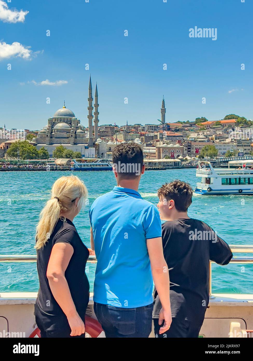 Istanbul, Turchia, 07.14.2022: Famiglia turistica di padre, madre e bambino su sfondo Istanbul. Donna, uomo, ragazzo, vista posteriore, in piedi sulla ringhiera del traghetto Foto Stock