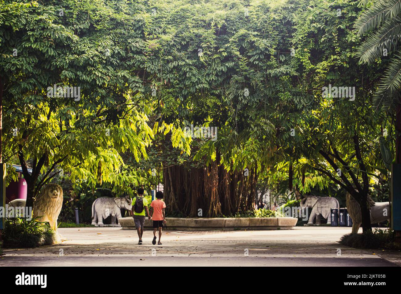 Una coppia che tiene le mani camminando lungo uno spazio spazioso presso il Garden by the Bay. Godetevi l'aria fresca e ottimo per viaggi di salute. Singapore. 2022. Foto Stock