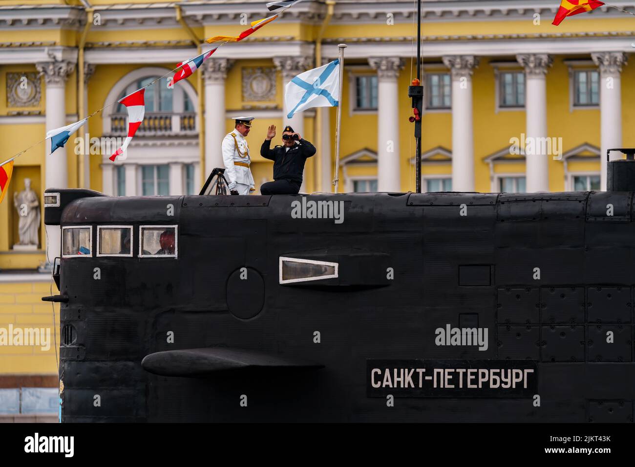 Russia, San Pietroburgo, 31 luglio 2022: Il comandante di un sottomarino che si trova nel centro della città guarda attraverso binocoli, è vestito in un Foto Stock