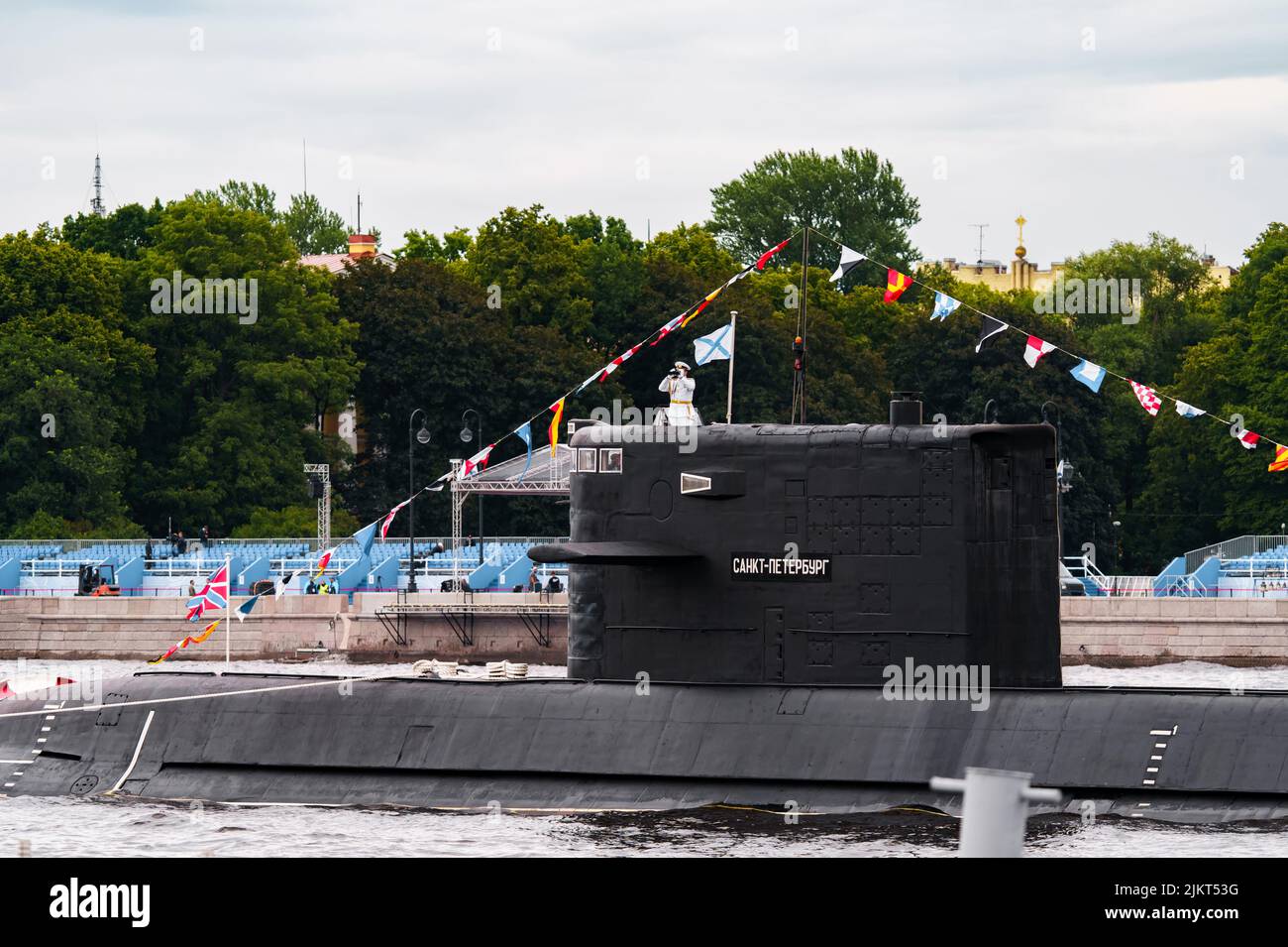 Russia, San Pietroburgo, 31 luglio 2022: Il comandante di un sottomarino che si trova nel centro della città guarda attraverso binocoli, è vestito in un Foto Stock