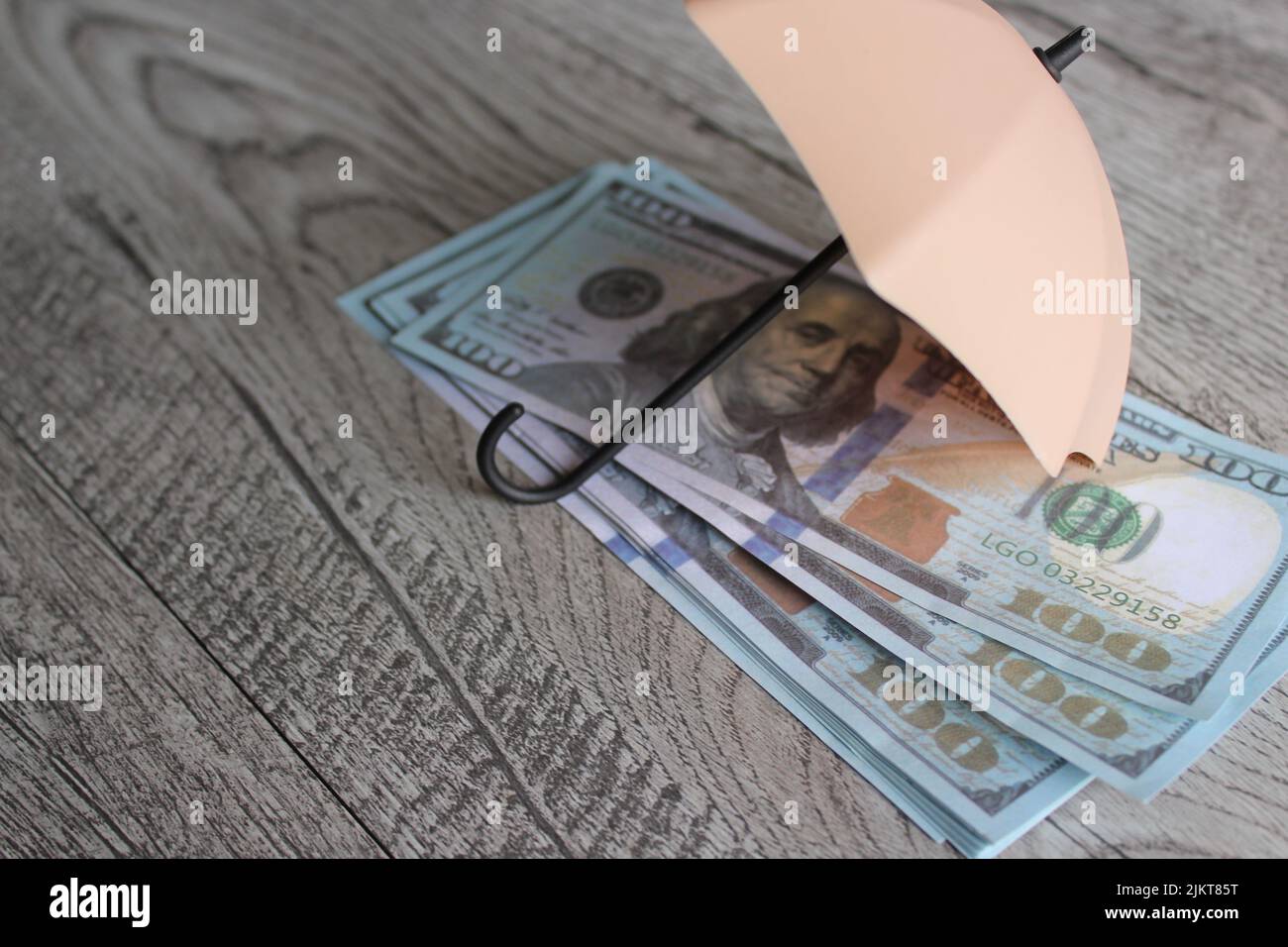 Pila di denaro e ombrello per la protezione con spazio per la copia. Sicurezza finanziaria e concetto di investimento. Foto Stock