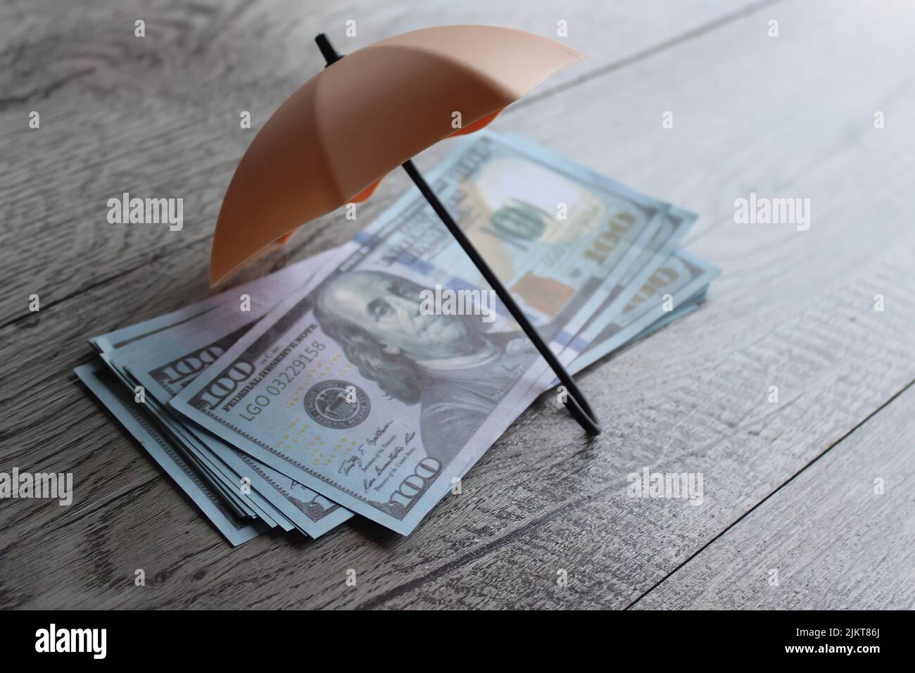 Pila di denaro e ombrello per la protezione con spazio per la copia. Sicurezza finanziaria e concetto di investimento. Foto Stock
