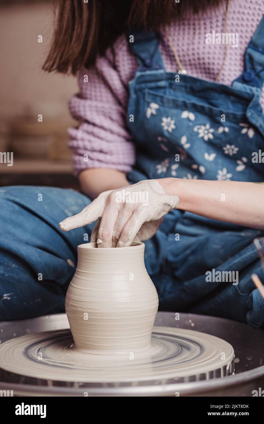 Primo piano sulle mani della donna creando vaso in ceramica fatto a mano. Workshop creativo. Foto Stock