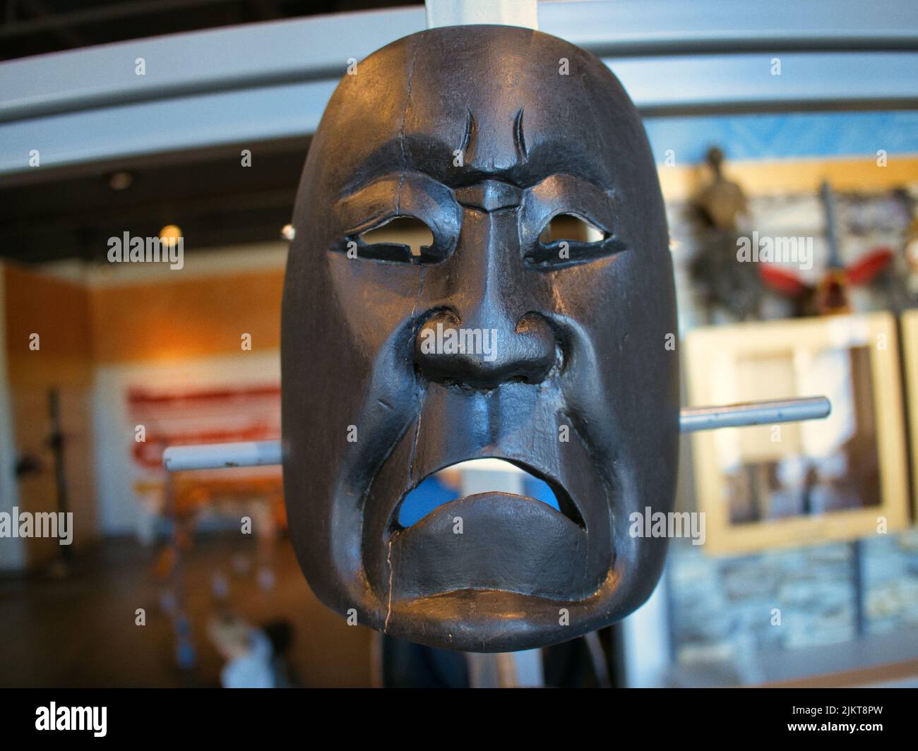 Una maschera nera di un uomo triste al Prairie Fire Museum di Overland Park, Kansas, USA Foto Stock