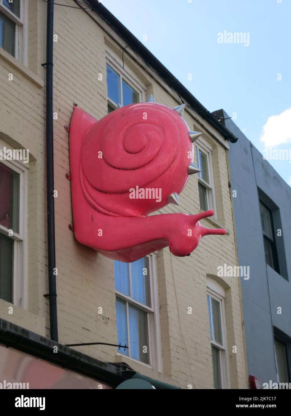Una vista di una figura di lumaca rosa su un muro Foto Stock
