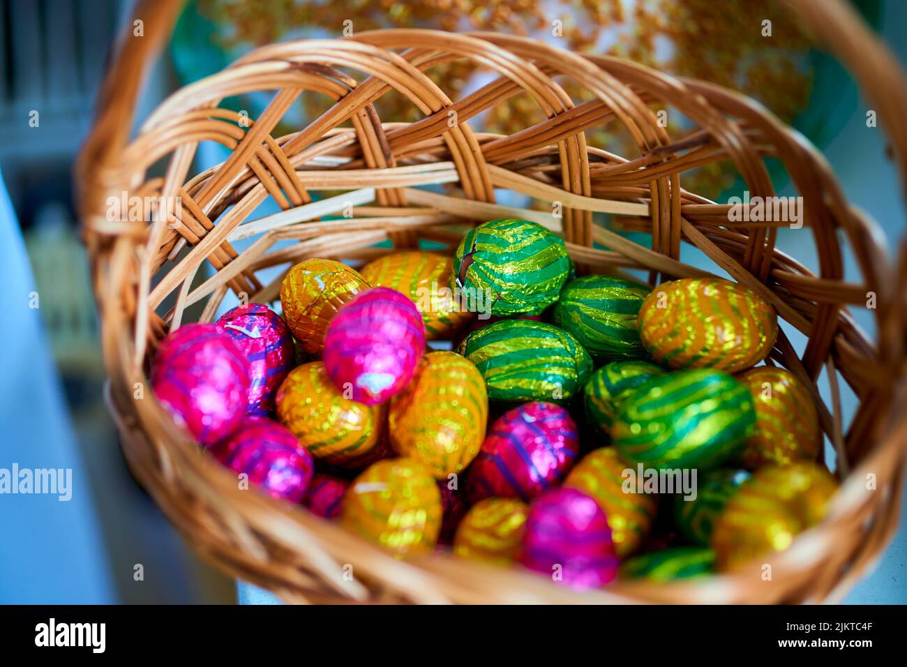 Un primo piano di un mucchio di uova di Pasqua al cioccolato in un cestino. Foto Stock