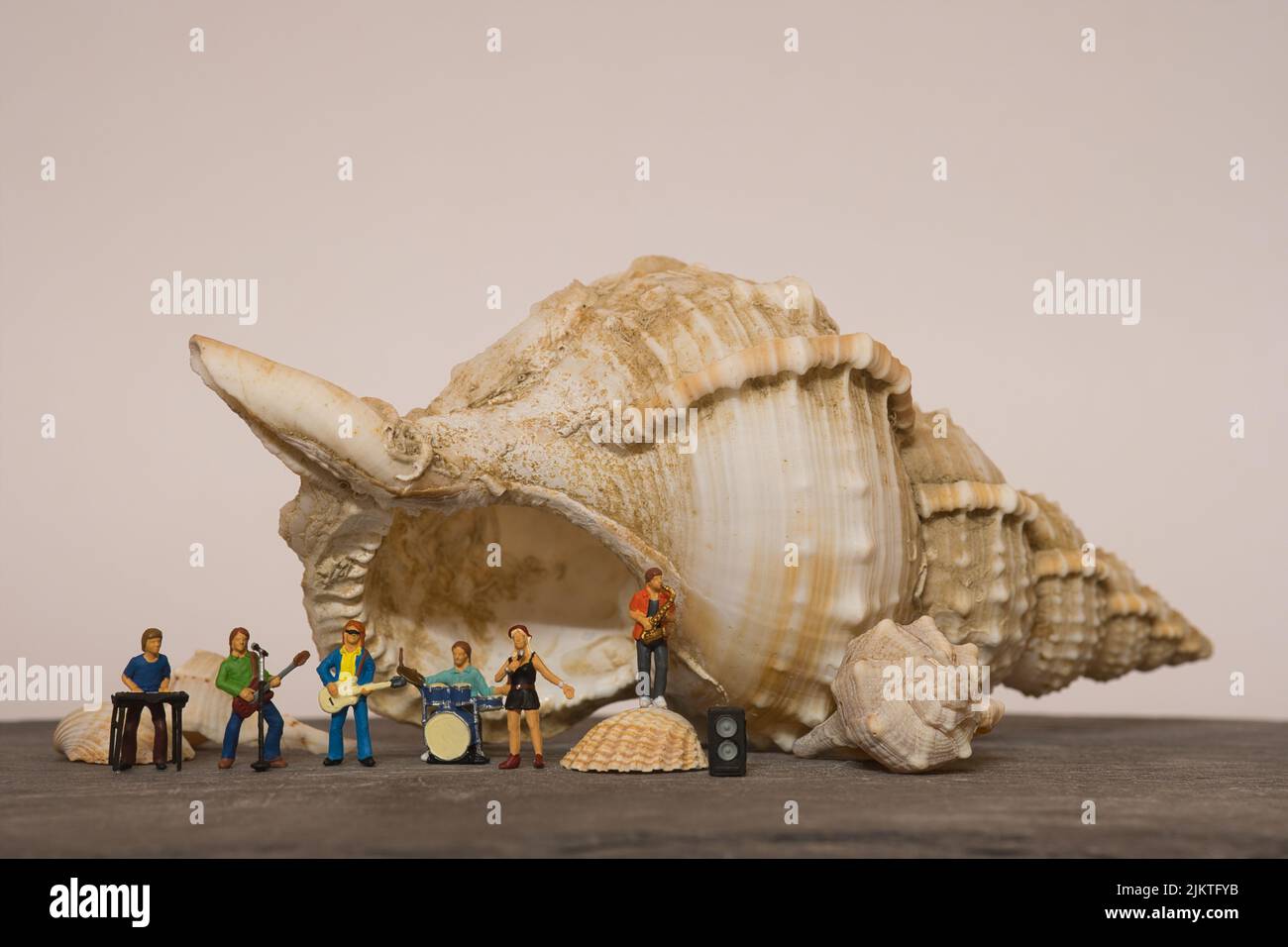 Band musicale di fronte a un enorme conchiglia, sfondo colorato caldo, spazio copia Foto Stock