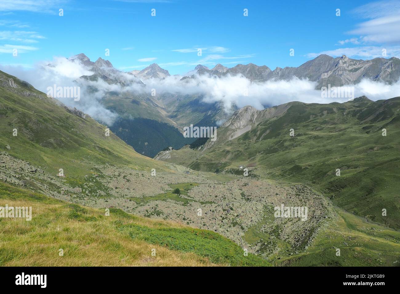 Una vista panoramica della catena montuosa dei Pirenei ricoperta di verde e nuvole Foto Stock