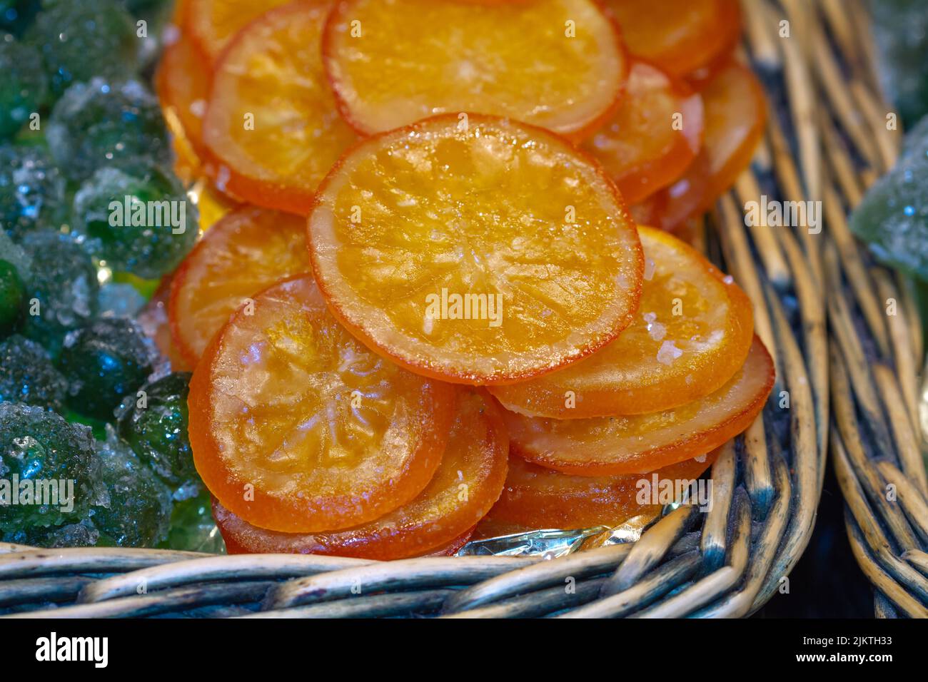 Fetta di arancia caramellata su un paniere di vimini in un mercato di Siviglia (Spagna), approccio selettivo. Foto Stock