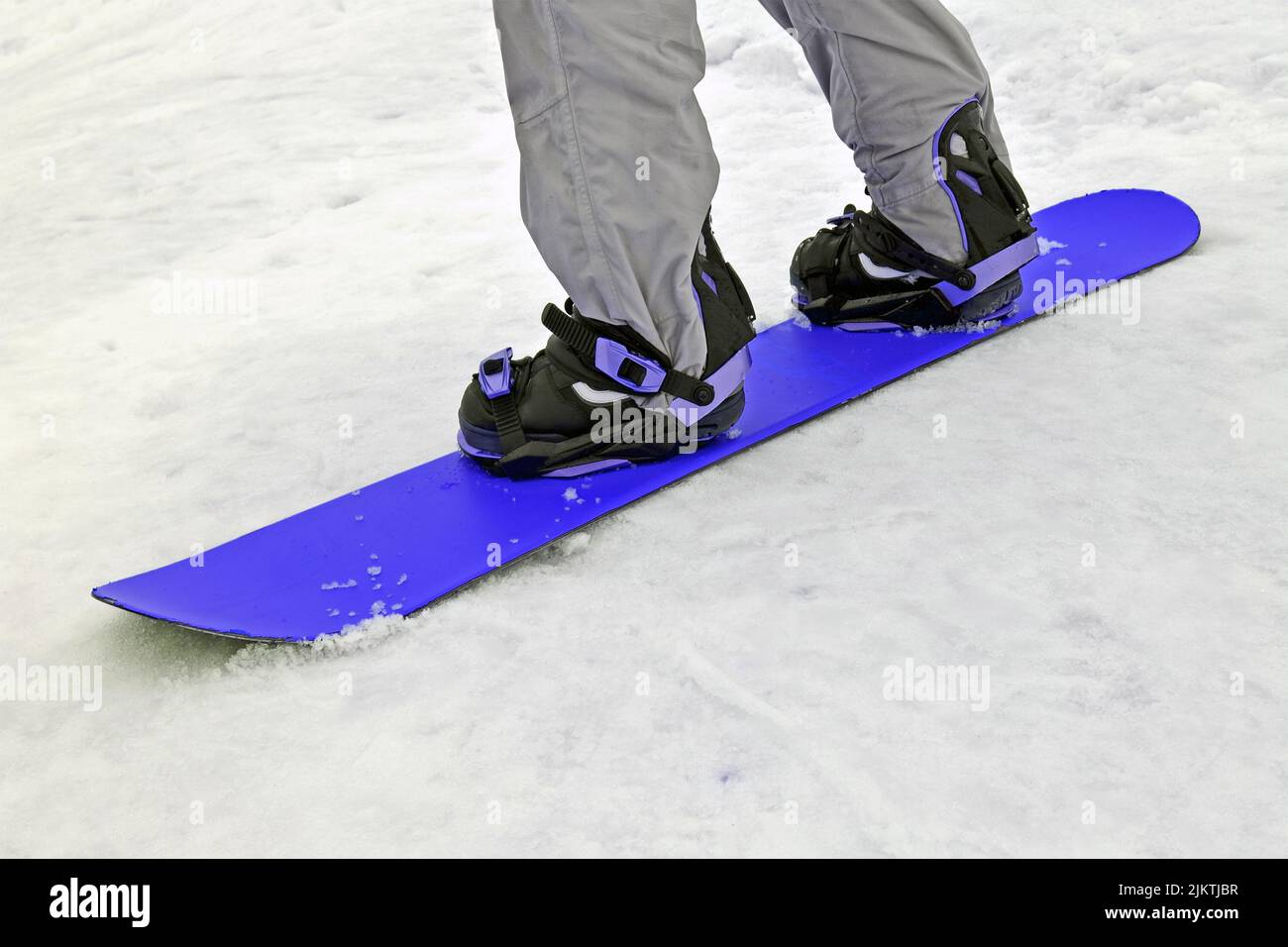 sportivo con snowboard blu sulla neve bianca, varietà sportiva stagionale Foto Stock