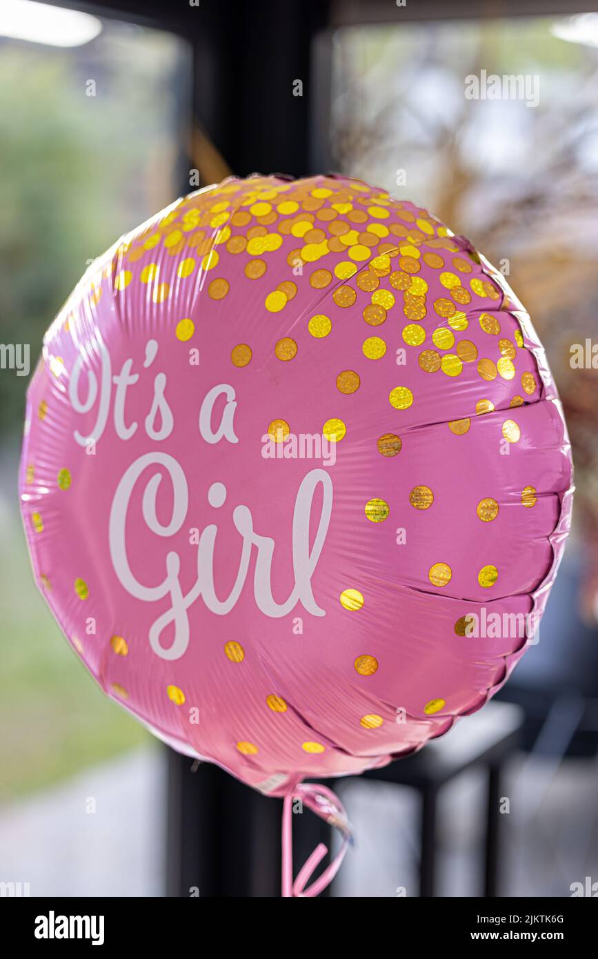 Una foto verticale di un palloncino rosa con la scritta "IT's a girl" in occasione di una festa di rivelazione di genere Foto Stock