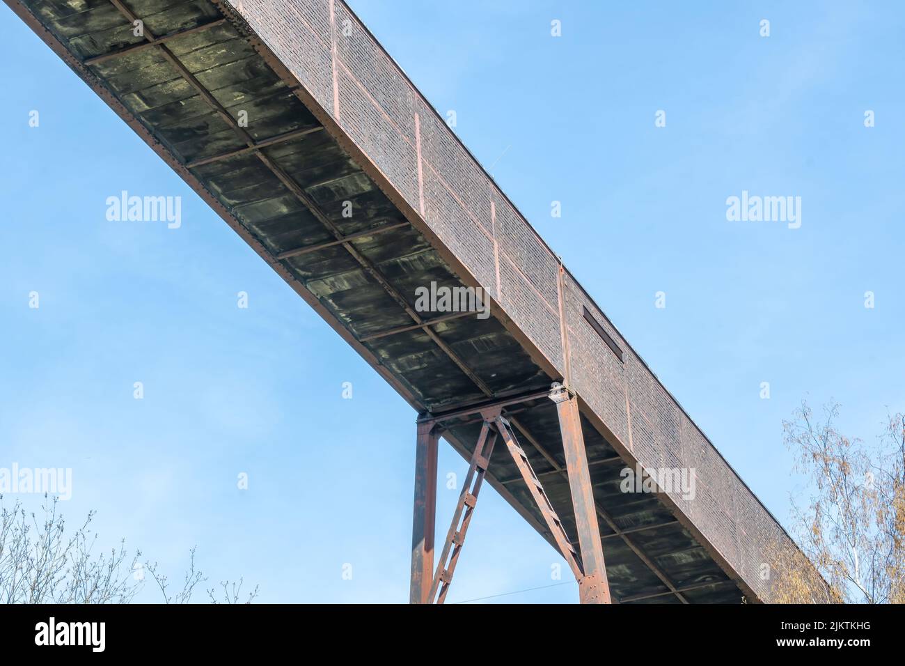 Un tiro a basso angolo di uno stretto ponte di metallo contro un cielo nuvoloso Foto Stock