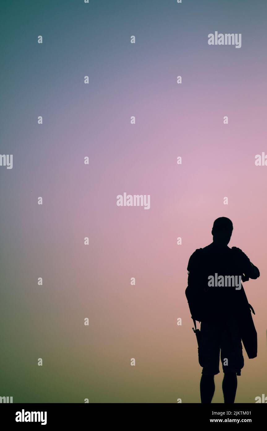 Una silhouette di un maschio al tramonto Foto Stock