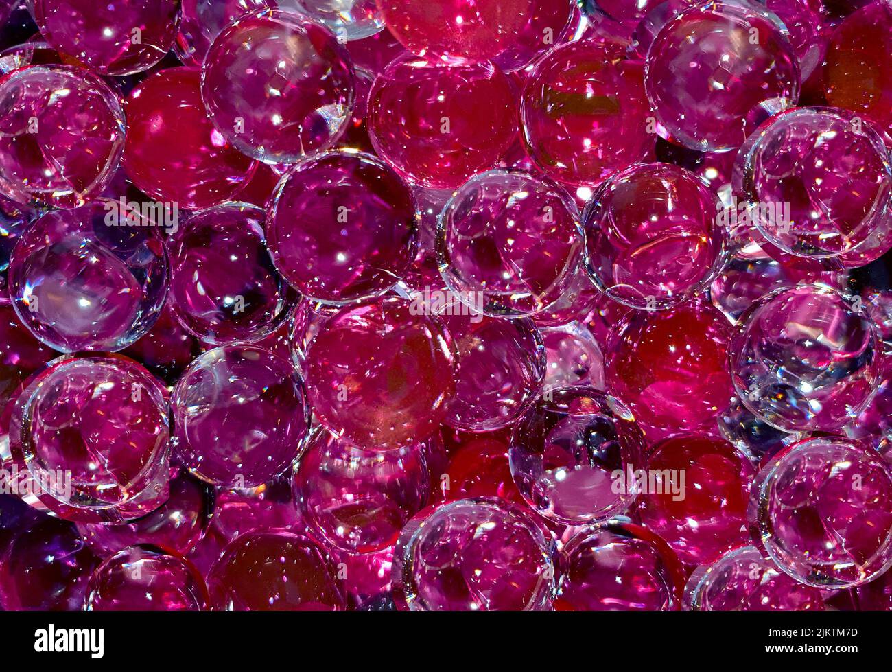 molte palline viola rosso trasparente in primo piano Foto Stock