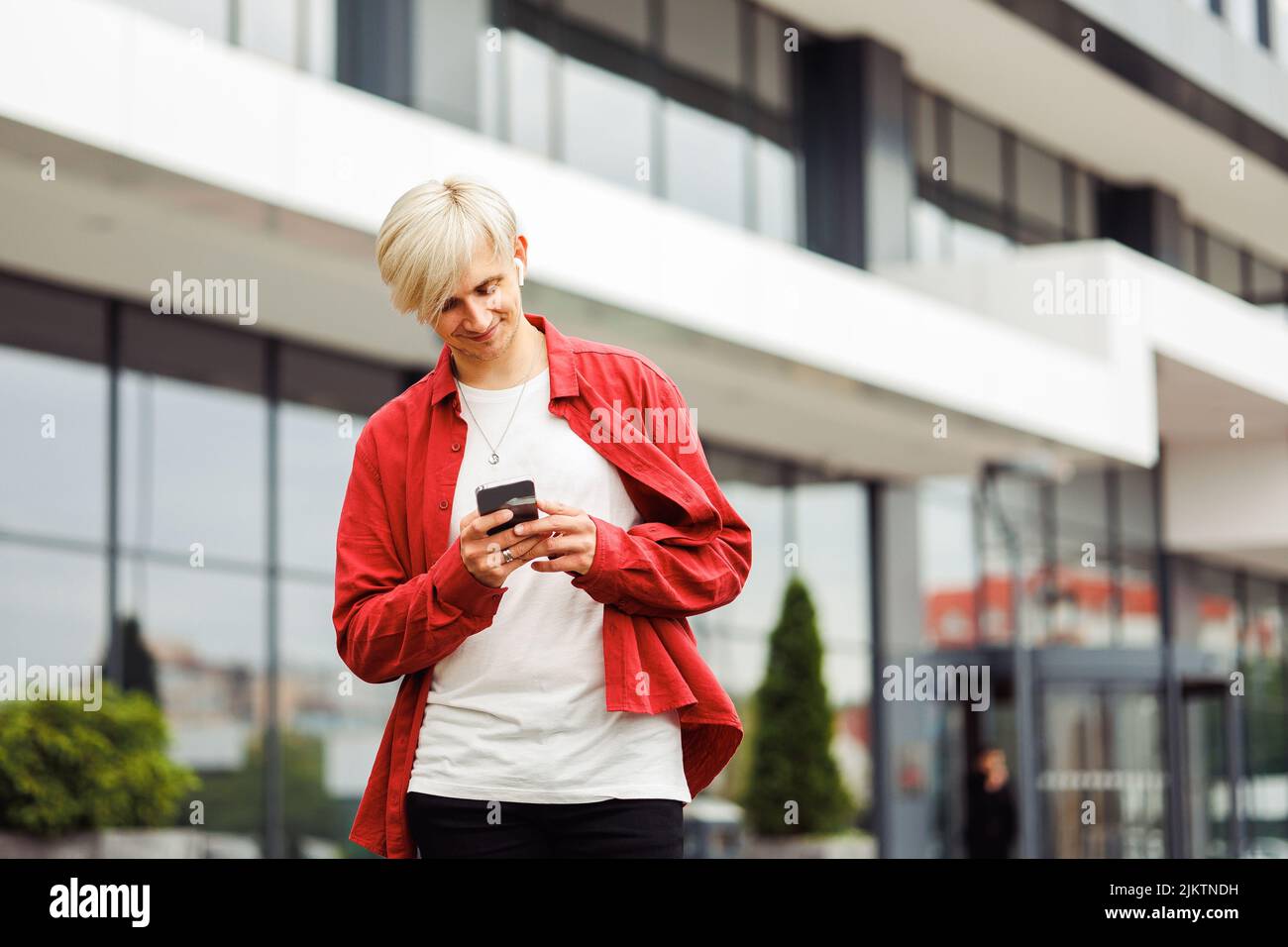 Uomo con un telefono a portata di mano utilizzando un'app. Foto Stock