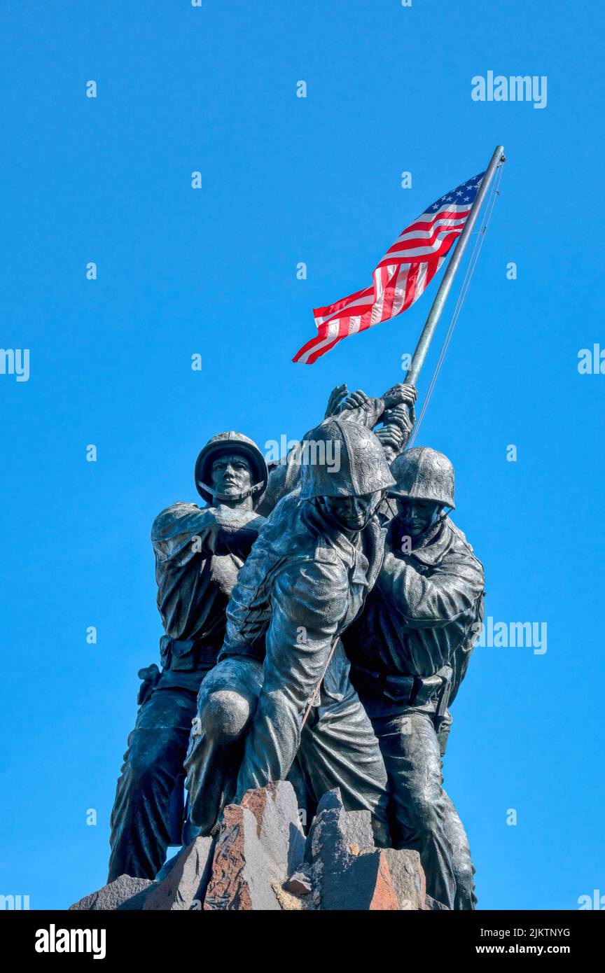 Uno scatto verticale del Marine Corps War Memorial con la bandiera degli Stati Uniti a Washington DC, Stati Uniti Foto Stock