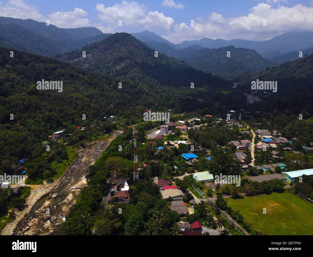 Un'immagine aerea delle lussureggianti montagne che circondano il villaggio di Kiriwong in Thailandia sotto un cielo nuvoloso Foto Stock