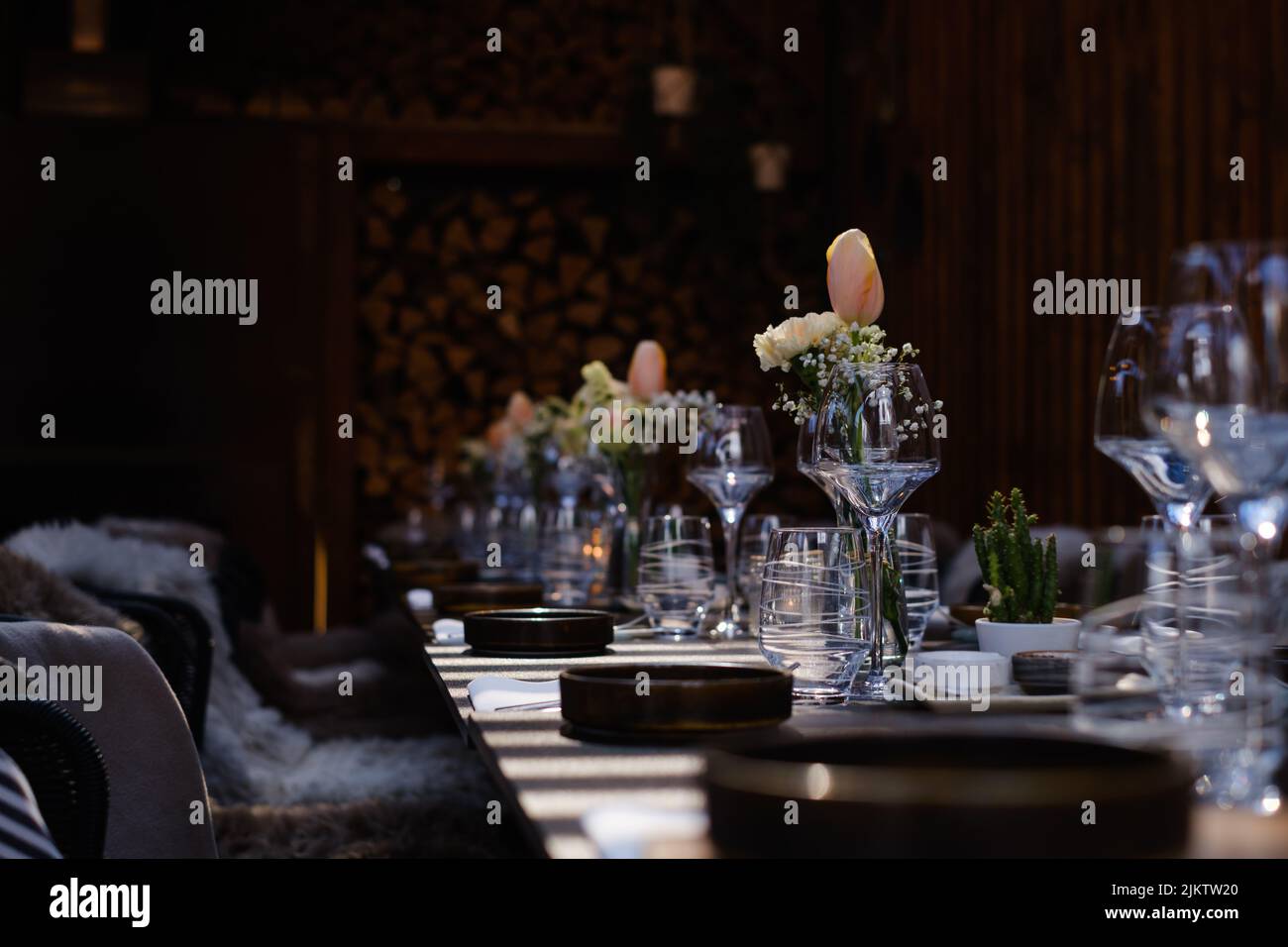 Una luce selettiva su fiori e piatti su un tavolo nel ristorante Foto Stock