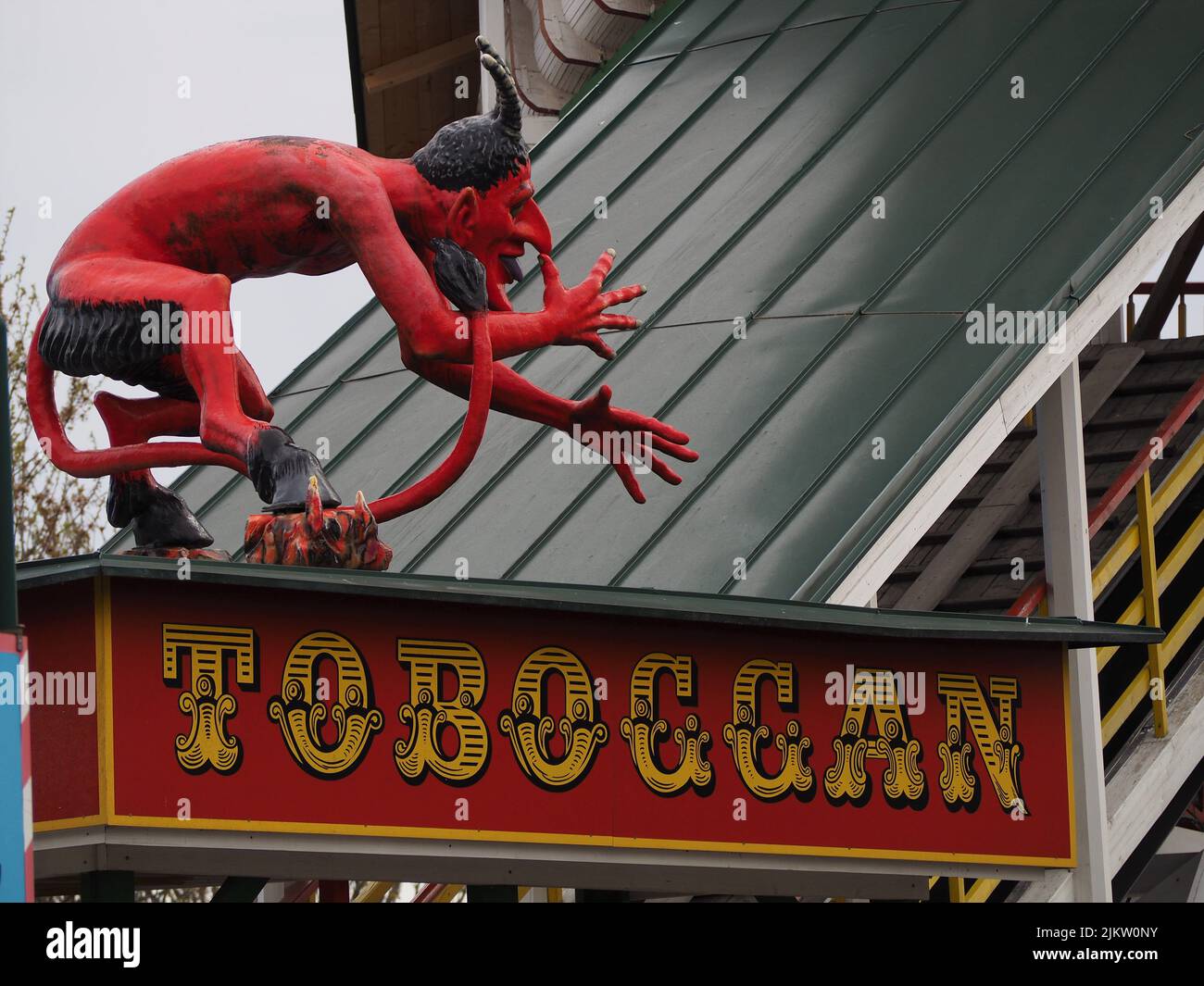 Insegna in slittino con statua del diavolo al wurstelprater di vienna, segno di un giro al parco divertimenti Foto Stock