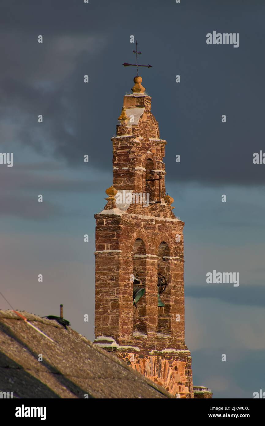 Un primo piano di una torre campanaria della chiesa sotto un cielo nebbioso Foto Stock