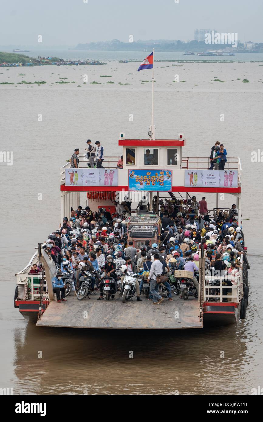 Un colpo verticale di una folla di persone su un traghetto durante un'ora di punta in serata, Cambogia Foto Stock