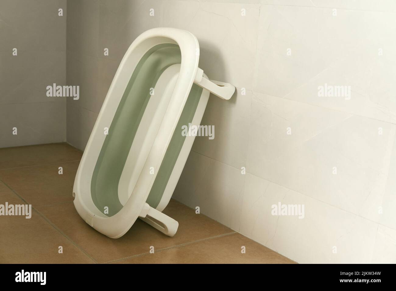 Una vasca da bagno per bambini appoggiata alla parete Foto Stock