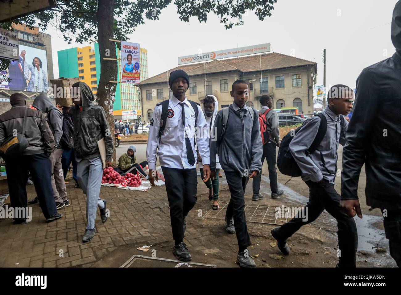 I pedoni e gli studenti camminano attraverso le trafficate strade del quartiere Centrale degli Affari di Nairobi mentre migliaia di studenti sono diretti per una breve pausa di tempo per Foto Stock