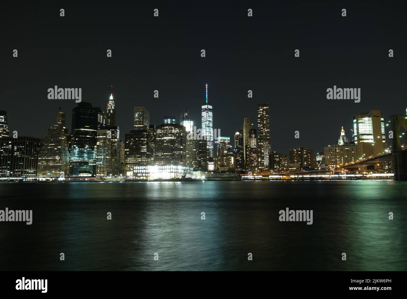 Lo scenario ipnotico dello skyline di New York City di notte dalla baia con luci luminose Foto Stock