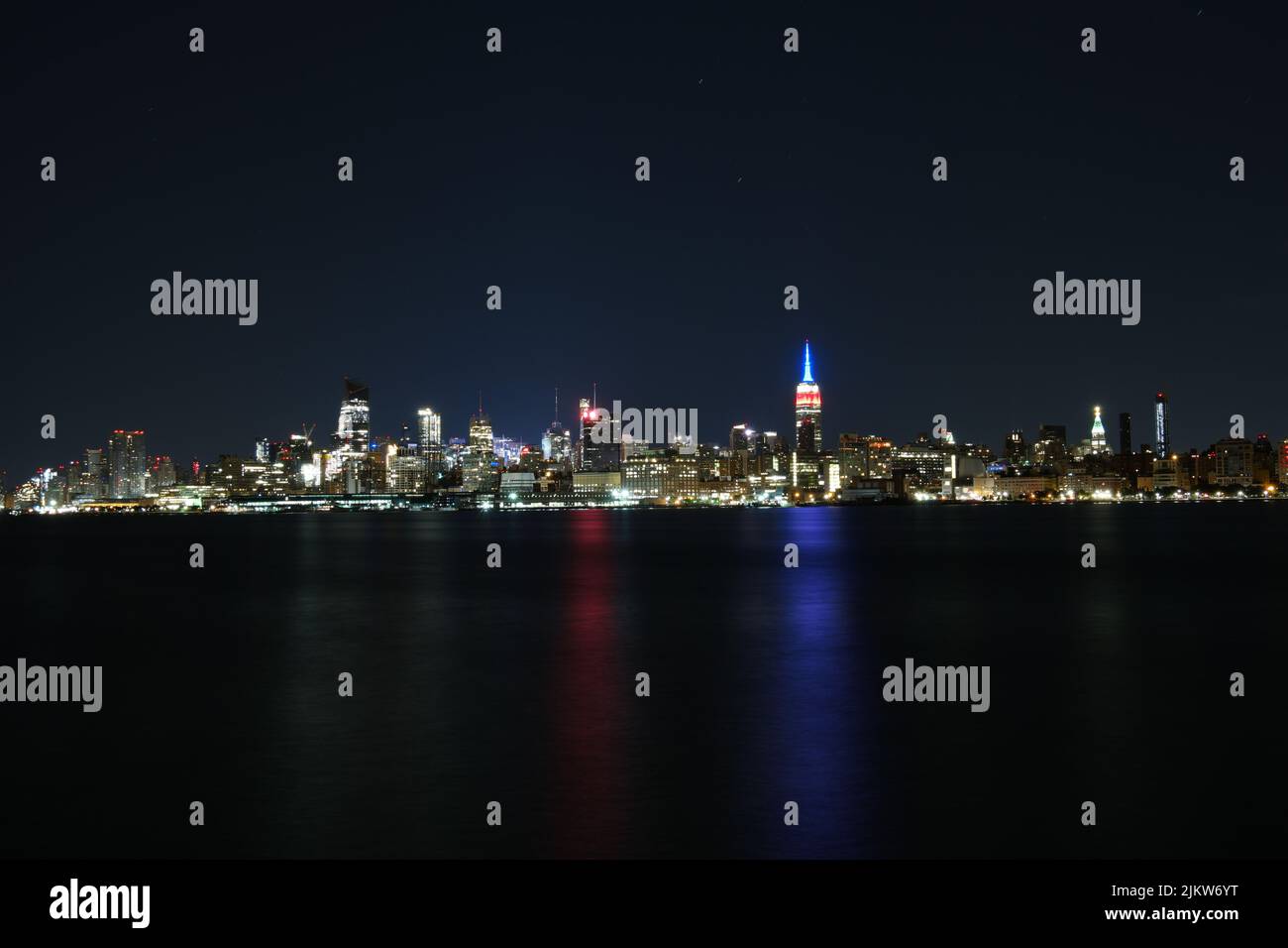 Uno scenario ipnotico dello skyline di New York con luci luminose dalla baia di notte Foto Stock