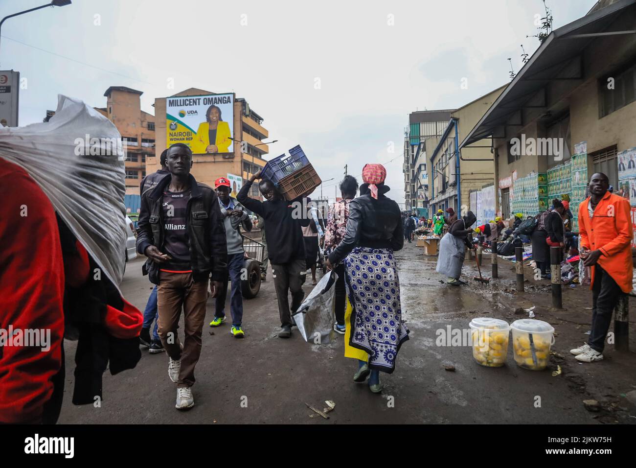 I pedoni passano accanto ai falchi che vendono i loro prodotti per le strade del quartiere centrale degli affari di Nairobi in Kenya. La maggior parte delle scuole keniote erano su Augus Foto Stock