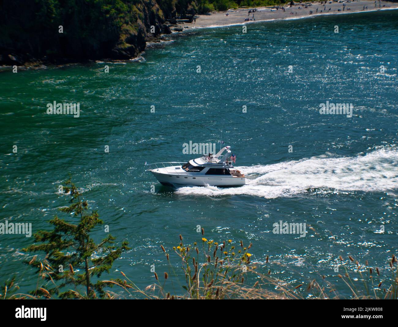 Uno scatto ad alta velocità di uno yacht che naviga sulla costa durante l'estate Foto Stock