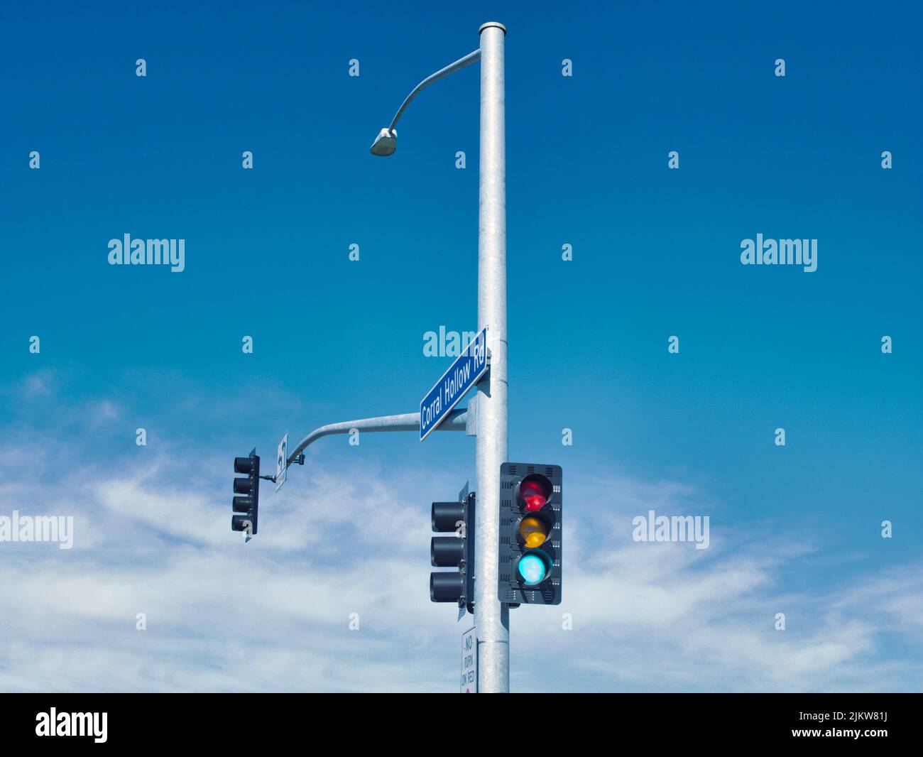I semafori sul palo su sfondo cielo nuvoloso blu a Tracy, California Foto Stock